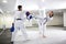 Martial arts competitors and their trainers practicing high kicks in taekwondo