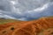 Martian landscape, natural landmark of Altai Republic. Mountains colored red, yellow, and orange against a blue sky with white