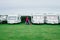 Martin`s Haven, Wales - June 30, 2017: Woman pitching a tent between camper vans at West Hook Farm Camping on a cloudy day in