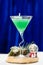 Martini glass with Christmas green cocktail on blue background