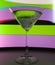 A martini glass with a cocktail in beautiful light of different colors