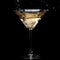 In a martini glass, vermouth ice falls, and splashes with drops on a black background