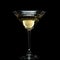 In a martini glass, vermouth ice falls, and splashes with drops on a black background