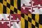 Maryland US state flag with big folds waving close up under the studio light indoors. The official symbols and colors in