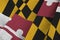 Maryland US state flag with big folds waving close up under the studio light indoors. The official symbols and colors in