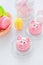 Marzipan in the shape of the symbol of the new year pink - pig, sweet delicate macaroons, marshmallows, peanuts in sugar pastel
