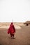 Masai or Maasai tribe man in red cloth in empty golden dusty land. Ngorongoro Consevation, Serengeti Savanna forest in Tanzania