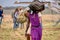 A Masai safari camp employee carries passenger baggage from a small plane.