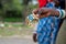 Masai Tribal Female Holds a Colorful Souvenir Bracelet for sale for tourist. Traditional Maasai Village Engare Sero in