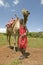 Masai Warrior in traditional red toga pose in front of his camel at Lewa Wildlife Conservancy in North Kenya, Africa