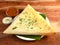 Masala dosa, a south Indian traditional and popular crepe with filling of a mixture of mashed potatoes and fried onions served