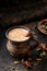 Masala pulled tea chai latte hot Indian sweet milk spiced drink, cinnamon stick, ginger, fresh spices and herbs blend