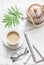 Masala tea, teapot, notepad, glasses, pen, green flower leaf on white background, top view. Morning inspiration planning.