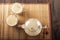 Masala tea on a textural wooden background. A teapot is a transparent tea pot with mugs and Indian national tea masala. Milk, ging