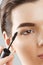 Mascara Closeup Of A Beautiful Young Woman A Face With A Beauty Makeup, Fresh Soft Skin Applying Mascara With Cosmetic Brush. Make