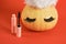 mascara in pink packaging mock up and pumpkin in santa hat and false eyelashes on red background