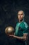 Masculine tattooed, bald fashionable male soccer player posing in a studio for the photoshoot with a soccer ball
