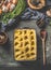 Mashed potato in casserole with spoon on dark rustic kitchen table background with ingredients and vintage utensils. Top view.