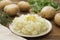 Mashed potatoes with butter and fresh white potatoes on background, wooden table. Healthy food for kids, dinner