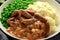Mashed potatoes and sausages, bangers with onions gravy, green peas. close up