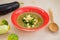 mashed zucchini soup, eggplant, broccoli in a red plate on a wooden background