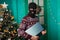 A masked bandit stole a laptop in the new year and escapes. A man in a balaclava holds a computer. Christmas background