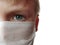 Masked child. The face of a 7-year-old boy in a protective white surgical mask close-up. Schoolboy with blond hair