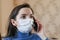 The masked girl calls the doctor on the phone. first signs of coronavirus