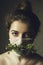 Masked girl during the coronavirus pandemic. Masked girl with green flowers