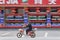 Masked man on e-bike passes a restaurant, Shanghai, China