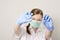 A masked nurse looks at a pill for virus COVID-19. Woman with protective mask hold medical pill in hand. problem and