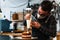 Masked pastry chef filling a cream cake with a piping bag