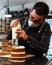 Masked pastry chef filling a cream cake with a piping bag