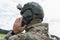 A masked soldier with a tactical helmet is on the phone. Soldier holding a cellphone with camouflage in his hand
