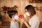 A masked son gives flowers to a masked mom. Mother`s Day on self-isolation. Family quarantined