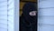 Masked suspicious man in balaclava opening door looking around stealing private property. Close-up portrait of male