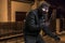 Masked thief in balaclava with crowbar wants to rob a house