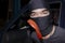 Masked thief with balaclava holding crowbar to breaking into a car. Crime concept