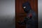 Masked thief with balaclava using crowbar to breaking into a house at night time. Crime concept.