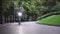 Masked young man riding eco friendly electric scooter with headlights on at park