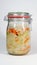 Mason jar with cabbage sauerkraut and carrots against light background