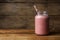Mason jar with delicious berry smoothie on wooden table. Space for text