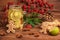 mason jar with ice tea with ginger, lime, cinnamon and gingerbread, decorated Christmas tree branch, cones, red berries and