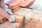 A mason person is bricklaying a wall of a new house from red bricks