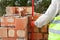 Mason worker measuring with professional level the bricks under construction