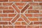 Masonry wall of bricks with a cross as decoration.