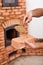 Masonry worker hands with brick and clay mortar on trowel