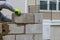 masonry worker make concrete wall by cement block and plaster at construction site