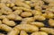 Mass of potato halves in peels baking on a grill