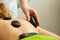 Massage with hot rocks stones in beautician